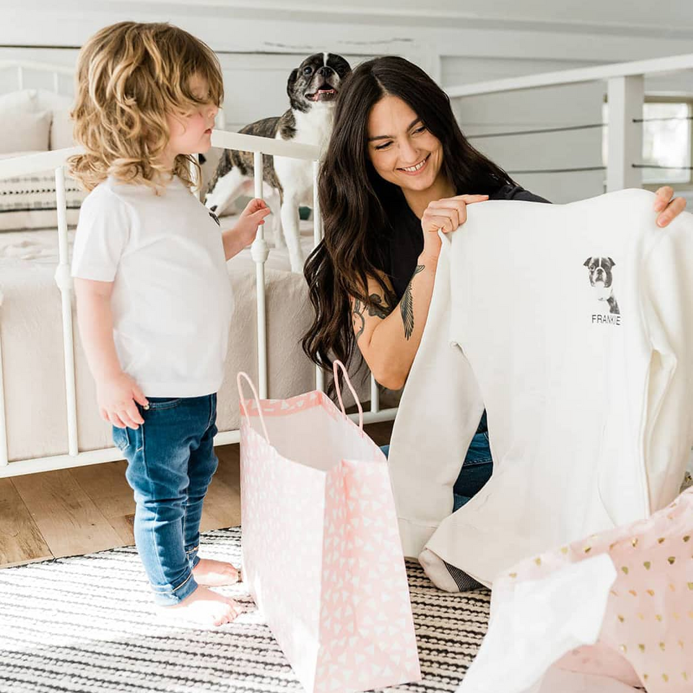 A pet parent opening a Perkie Print sweatshirt of their own dog