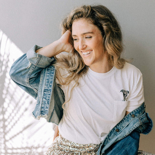 Woman wearing a white t-shirt and denim jacket indoors