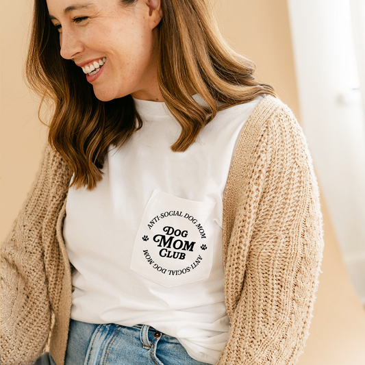 Woman wearing a white t-shirt with 'Dog Mom Club' text, smiling.