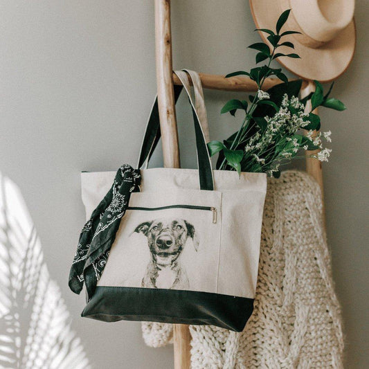 Canvas tote bag with zipper closure and custom pet portrait on the exterior pocket. 