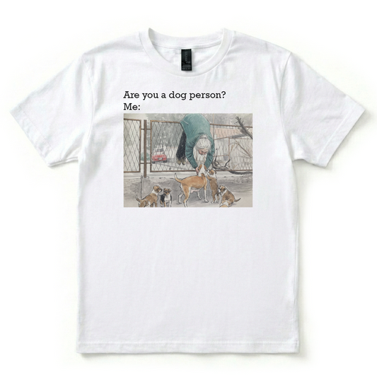 White t-shirt with a graphic of a person and dogs, text 'Are you a dog person? Me:', on a white background.