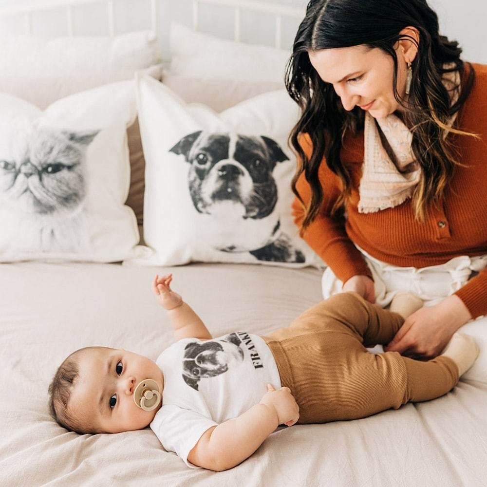 mom and baby with customized baby onesie and throw pillow covers